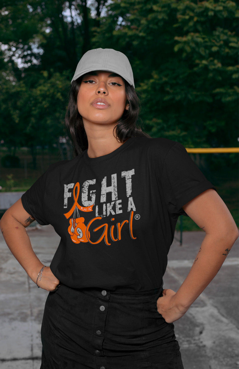 Woman wearing a black unisex t-shirt with the Fight Like a Girl Knockout design in orange on the front. The design says "Fight Like a Girl" and includes boxing gloves hanging from an orange awareness ribbon.