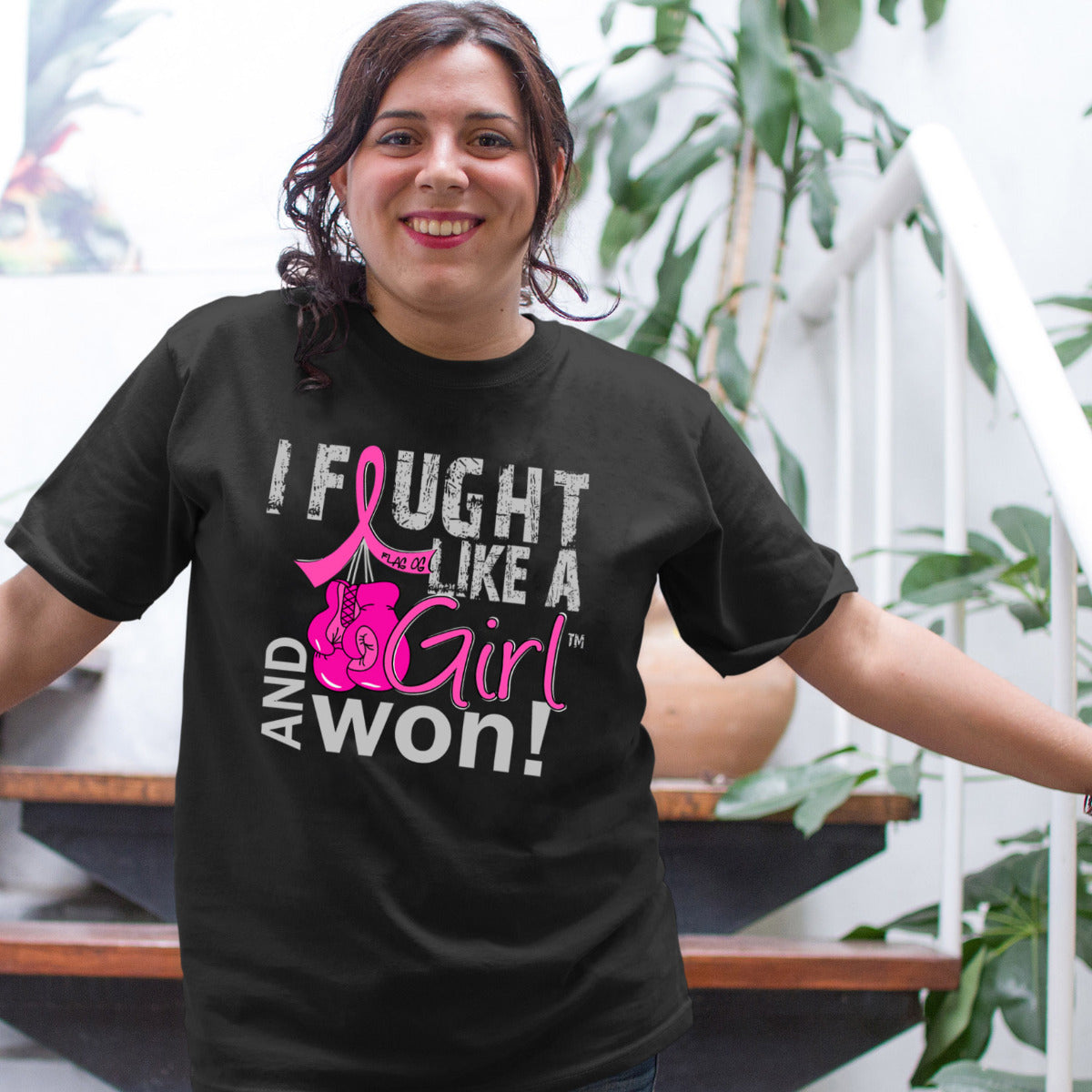 Woman wearing a black unisex t-shirt with the I Fought Like a Girl Knockout design in pink printed on it.