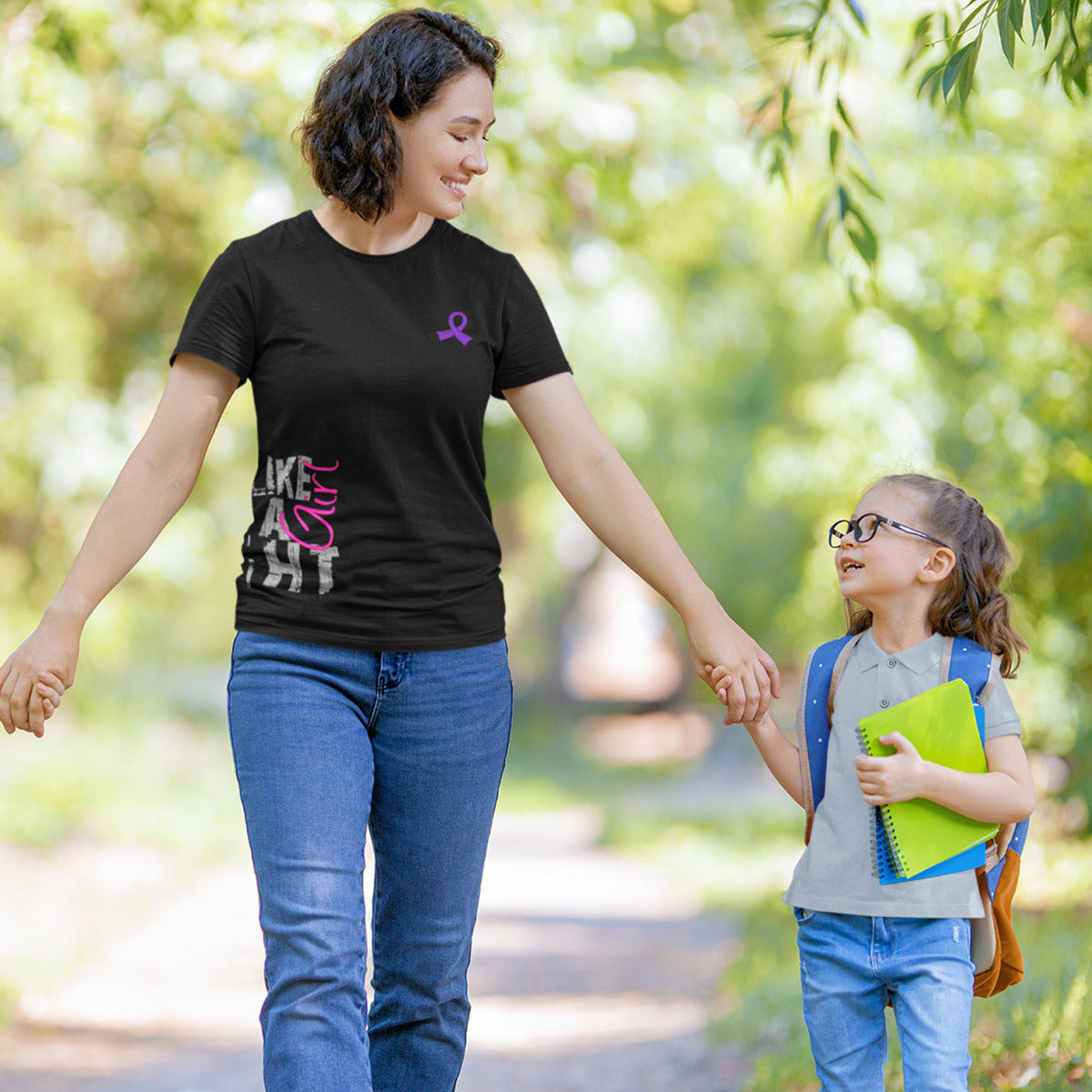 Woman wearing a black women's fit t-shirt with the Fight Like a Girl Side Wrap design in purple and pink printed on it.