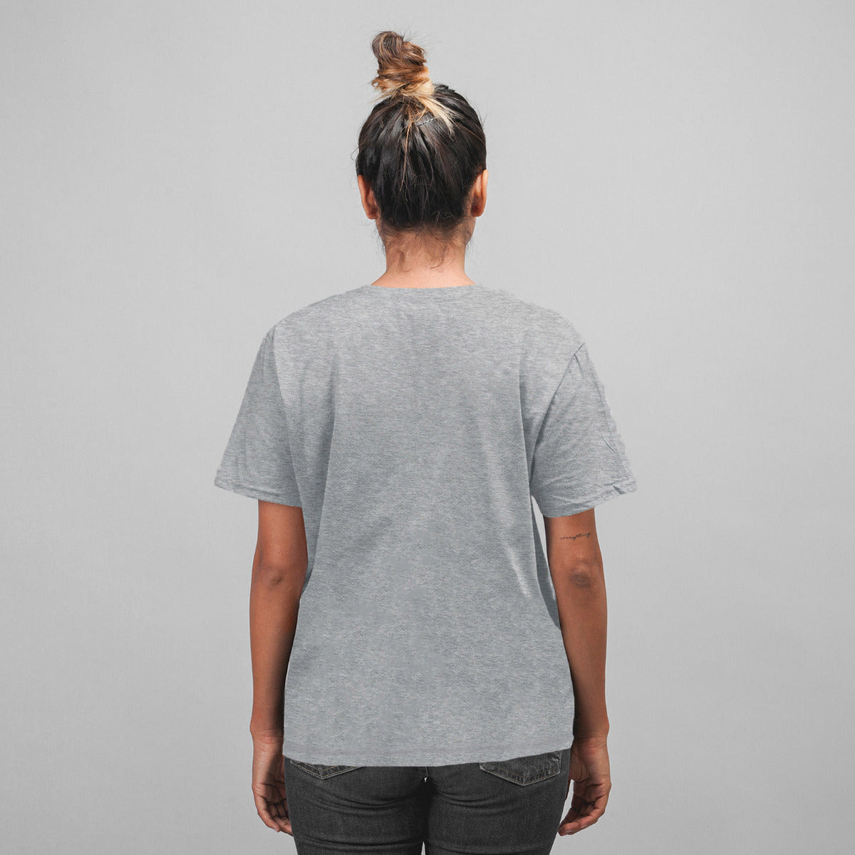 Back of woman wearing a heather grey unisex t-shirt.  The back of the shirt doesn't have any artwork printed on it.